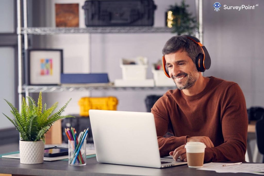 Man with headphones at desk creating Sampling Frame Design with laptop
