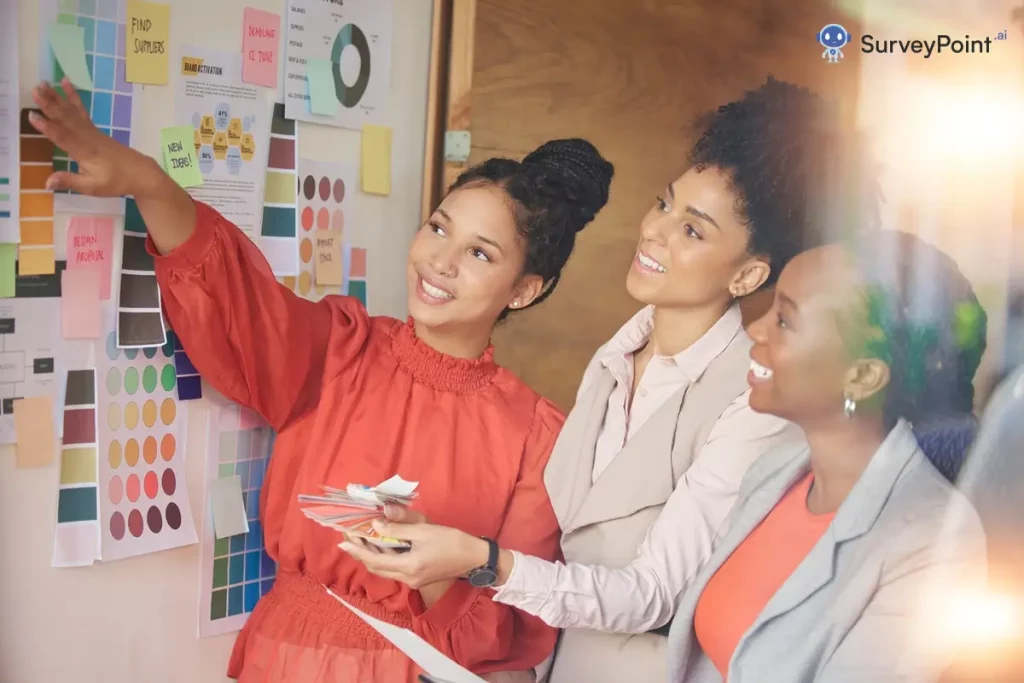 Three women in a survey panel looking at a whiteboard with a design.