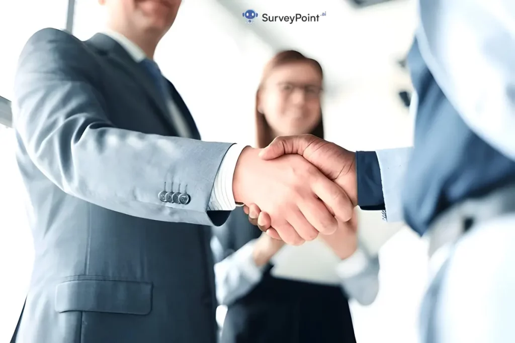 Business professionals shaking hands in an office setting, symbolizing collaboration and agreement on belonging survey questions.