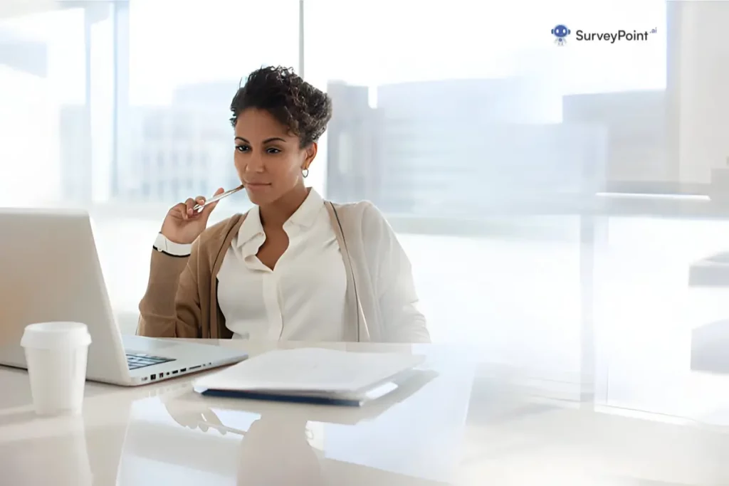 A woman seated at a desk, focused on her laptop, surrounded by a quiet workspace, reflecting low response rates.