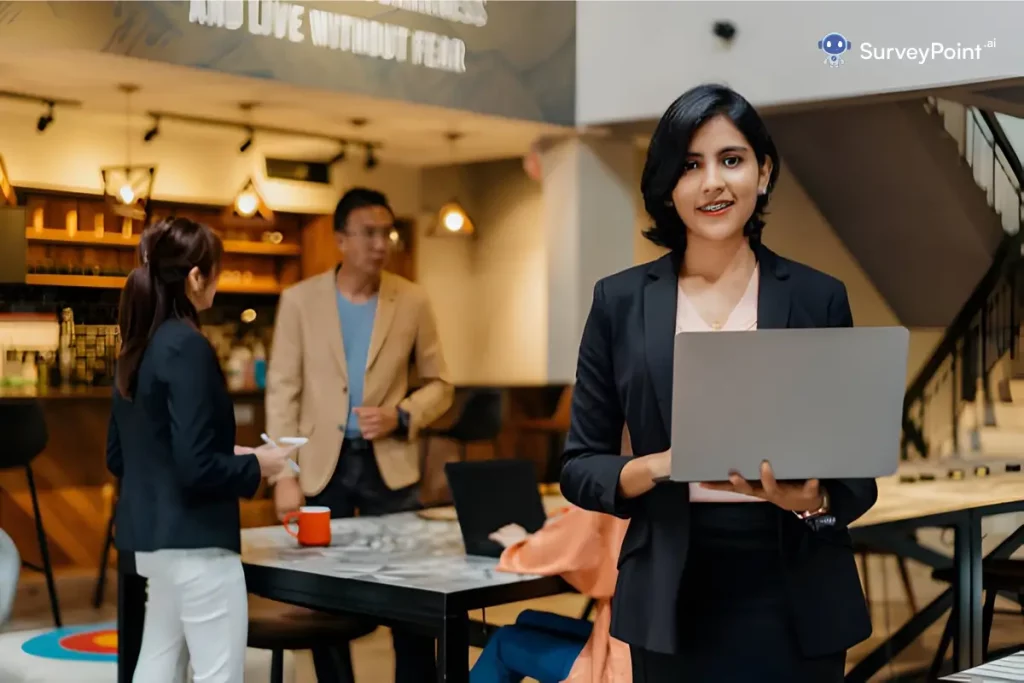 A professional woman in a business suit confidently holds a laptop, representing insights from the Coca Cola Consumer Survey.