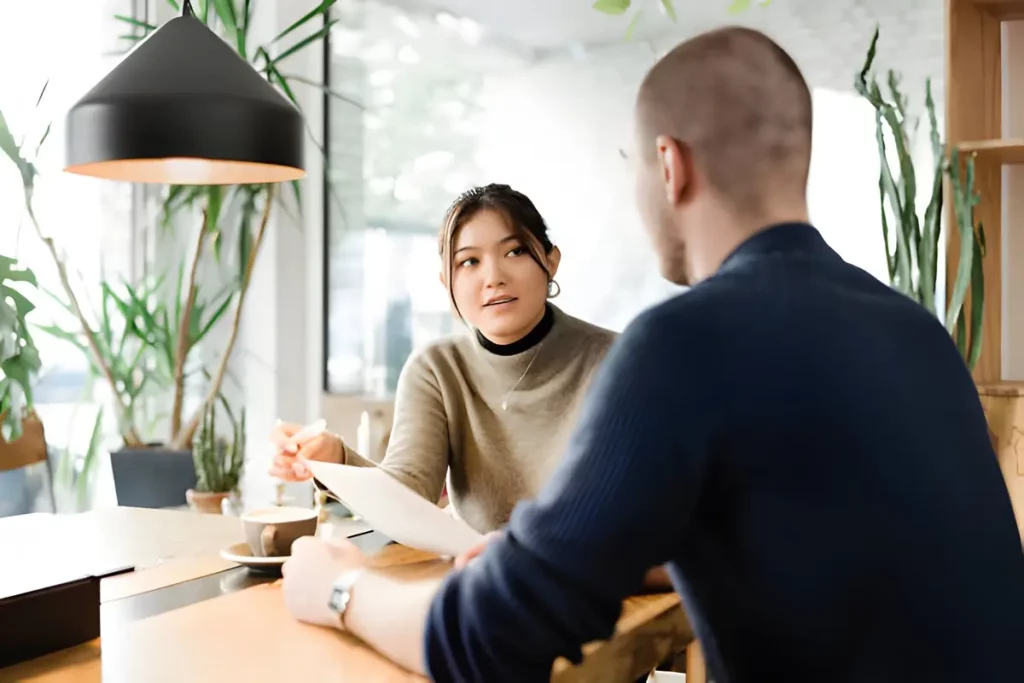 A man and woman seated at a table in an office, discussing the Student Feedback Survey for Teachers.