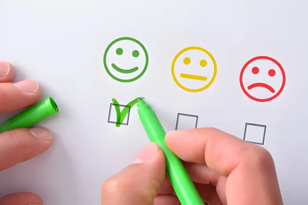 A person writes a smiley face on a whiteboard with a green pen, symbolizing positive feedback in phone service surveys.