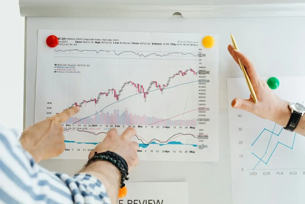 Two individuals analyzing graphs on a whiteboard, discussing insights from an employee survey email template.