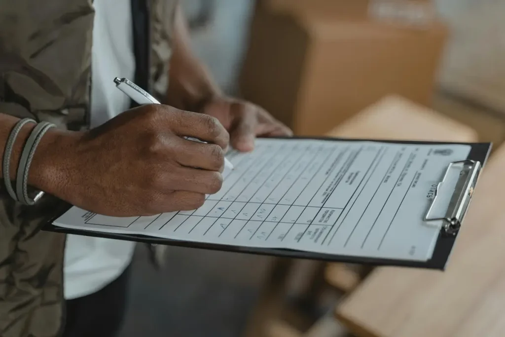 A man diligently writing on a clipboard, focused on enhancing sales through a lead survey to boost conversions.